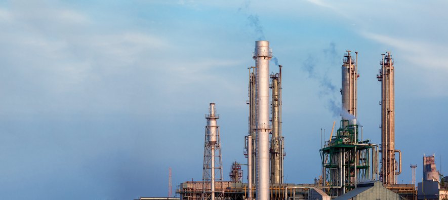 Torres metálicas de indústria química soltando fumaça no ar