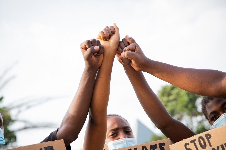 Pessoas negras erguendo os punhos como protesto contra o racismo e a discriminação racial