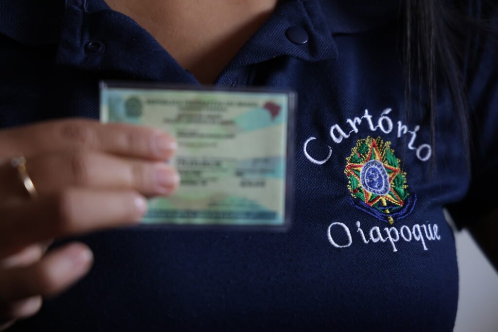 pessoa segura documento de identificação e usa camisa com a inscrição - cartório oiapoque