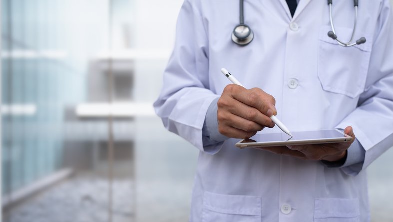 Médico fazendo anotações em tablet