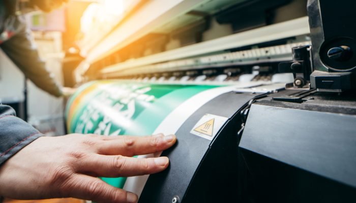 Trabalhador gráfico operando máquina de impressão