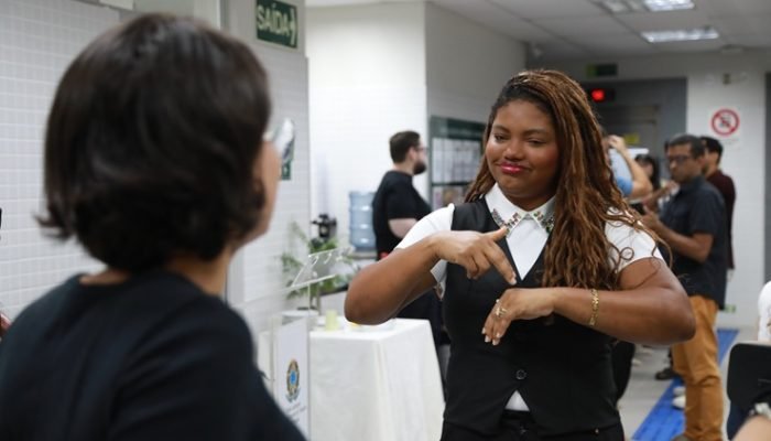 Duas mulheres conversam um de frente para a outra em Libras (Língua Brasileira de Sinais)