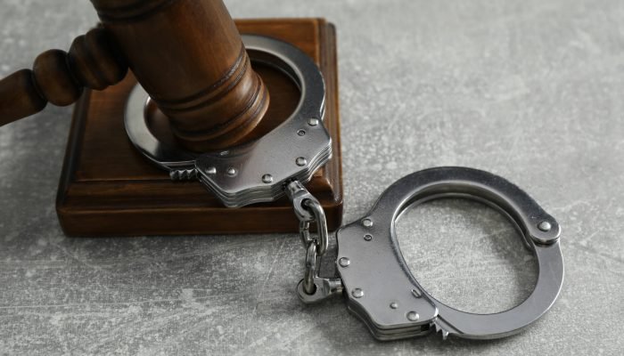 handcuffs-judge39s-gavel-grey-textured-table-closeup-scaled.jpg
