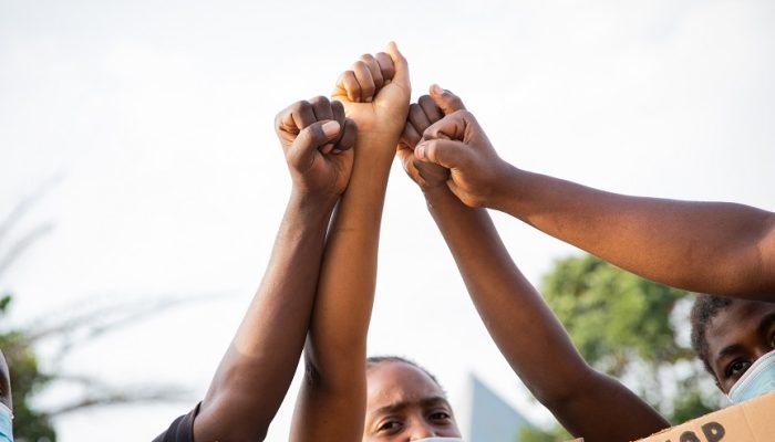 Pessoas negras erguendo os punhos como protesto contra o racismo e a discriminação racial